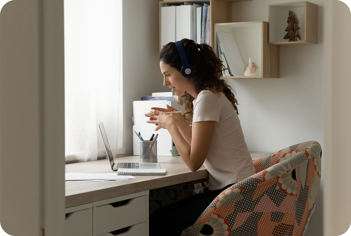 Person with headphones working on a laptop.
